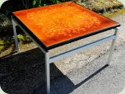 Kvadratiskt sidobord
                          eller soffbord med stomme i aluminium och
                          skiva målad i orangerött, 70-tal