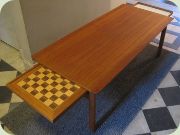 Soffbord i teak med
                          uppsvängda långsidor, en vändbar utdragsskiva
                          med schackbräde, en med vitt laminat. Tove
                          & Edvard Kindt Larsen för Seffle
                          Möbelfabrik.
