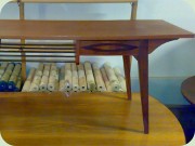 Teak coffee table with
                          brass magazine shelf and drawer with eye
                          shaped decoration